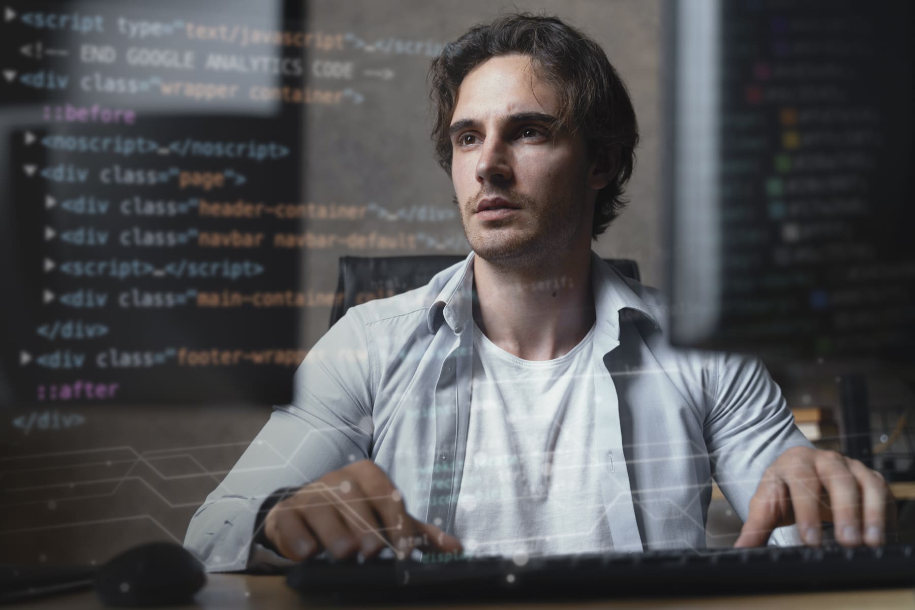 Profissional de TI programando em computador com códigos na tela, focado no desenvolvimento de software.