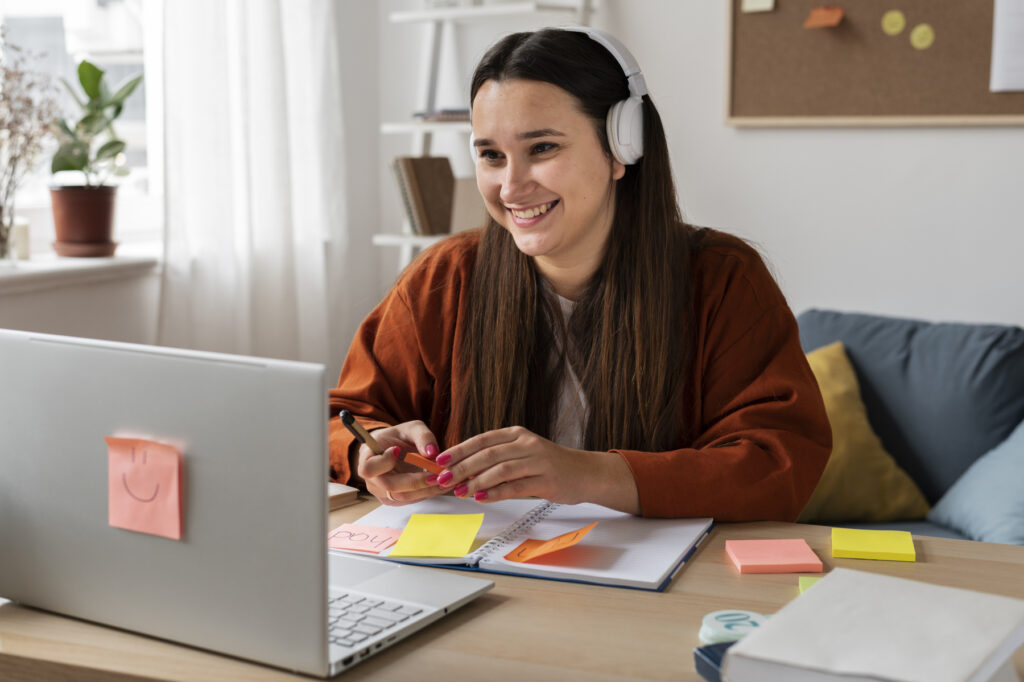 Mulher estudando online com fones de ouvido, ilustrando a diferença entre curso técnico e profissionalizante.