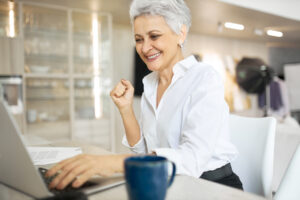 Mulher sorridente comemorando, representando a conquista de uma oportunidade de estágio e trainee após processo seletivo.