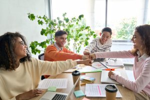 Grupo de trabalhadores, felizes e se tocando com os punhos em sinal de celebração pela harmonia que eles têm no ambiente de trabalho como um time.