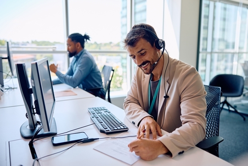 técnico em vendas sorridente anotando informações durante atendimento ao cliente.