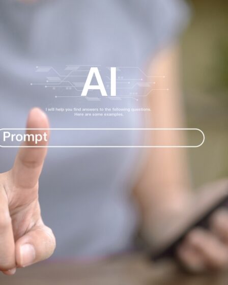 Imagem embaçada ilustrando uma pessoa com um celular na mão e simulando um touch screem na dela como se escrevesse um prompt.