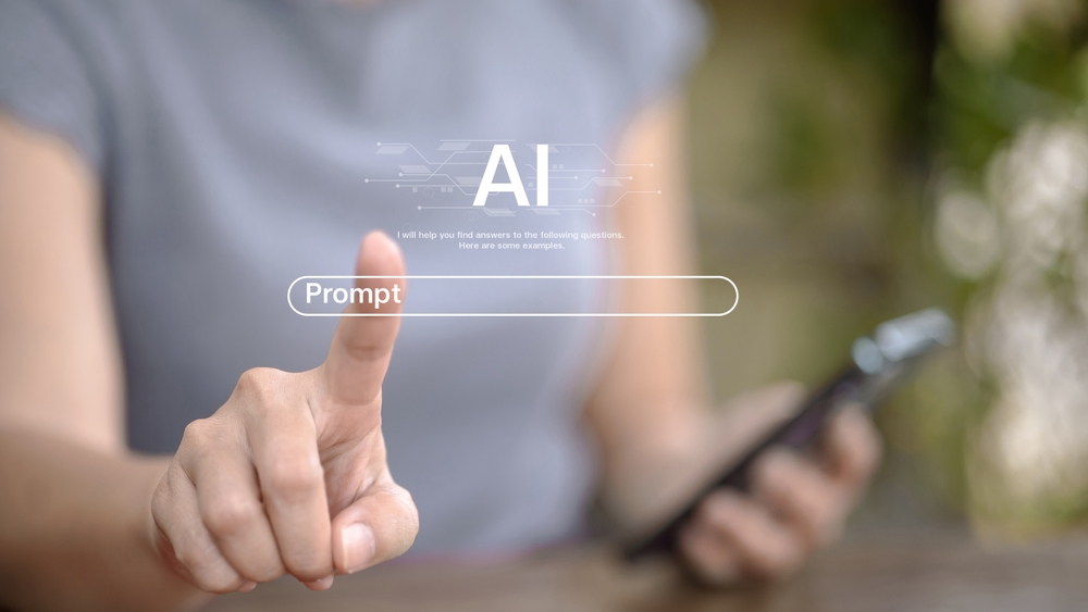 Imagem embaçada ilustrando uma pessoa com um celular na mão e simulando um touch screem na dela como se escrevesse um prompt.