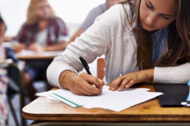 mulher responde questão de uma prova de concurso público.