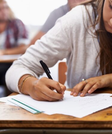 mulher responde questão de uma prova de concurso público.
