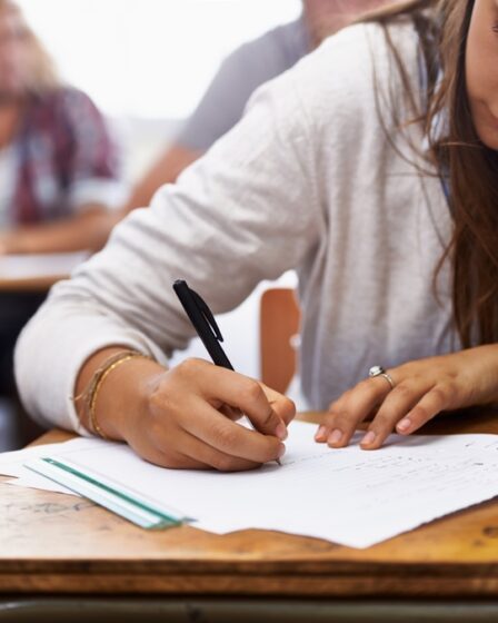 mulher responde questão de uma prova de concurso público.