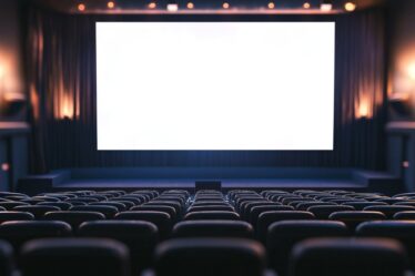 Imagem de uma sala de cinema completamente vazia vista da parte de trás, como se fosse a visão do projetor.