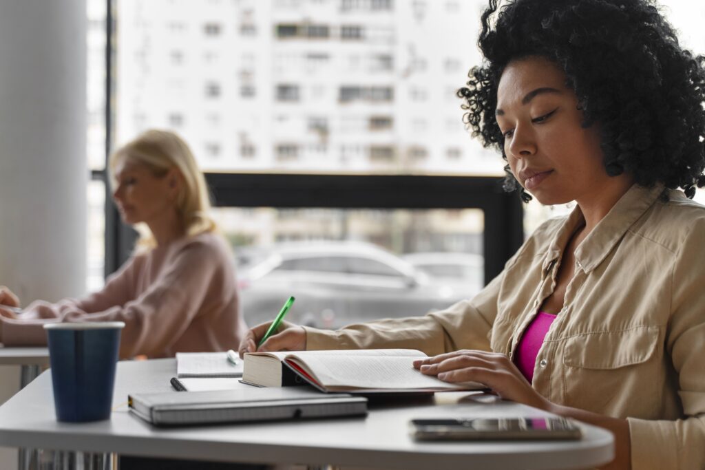 Mulher jovem fazendo anotações em um caderno, representando a busca por qualificação profissional e interesse nos cursos técnicos mais valorizados.