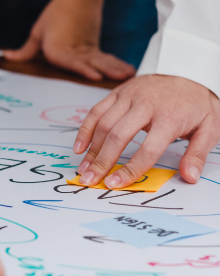 Grupo organizando ideias com post-its e palavras-chave em papel, exemplo prático de como fazer um mapa mental colaborativo