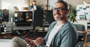 Programador, homem de negócios feliz e retrato com tablet para desenvolvimento de software, banco de dados de ai e código online. Engenheiro, rosto e gerente maduro em tecnologia digital com óculos em start-up criativa