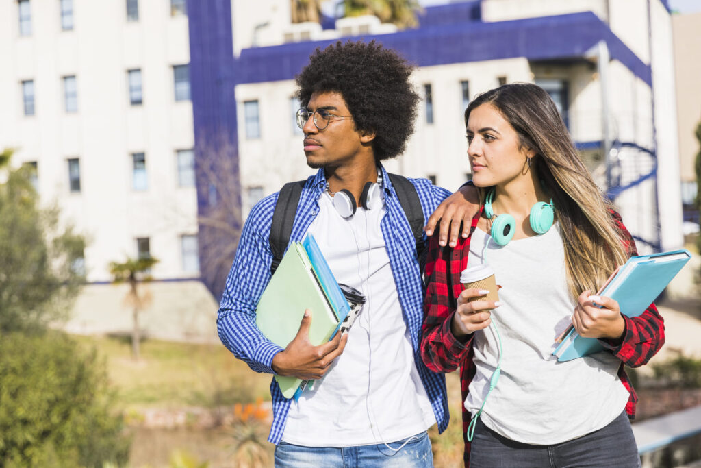 Estudantes universitários caminhando juntos, com mochilas, ilustrando como funciona o Prouni para ingressar na universidade.