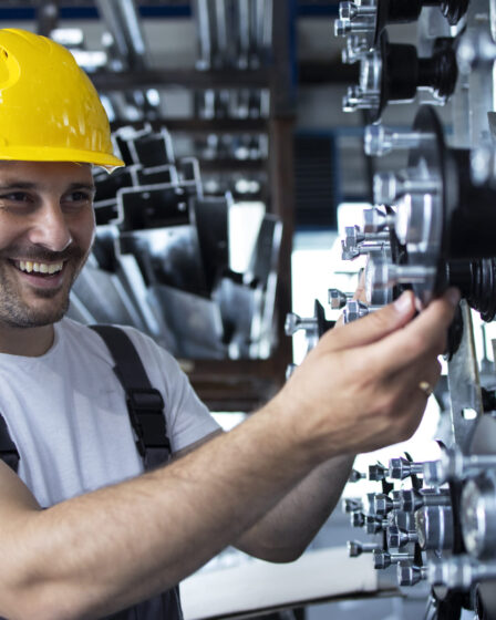 Profissional trabalhando em uma máquina industrial, representando as habilidades desenvolvidas na faculdade de Engenharia Mecânica.