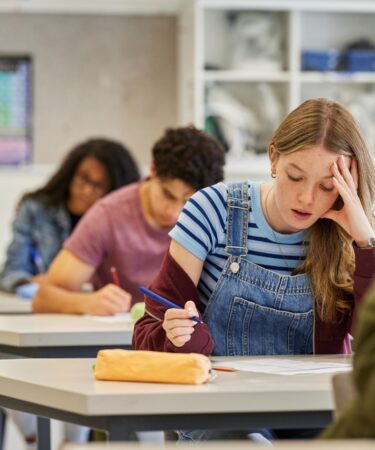 Estudante em sala de aula se preparando para o Enem 2026.