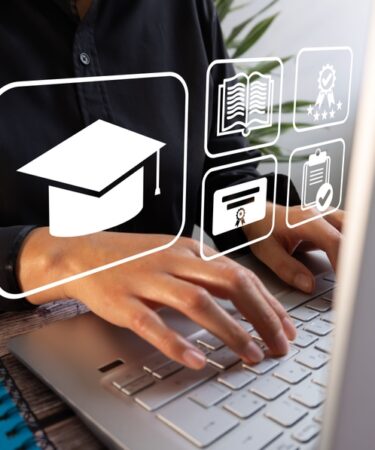 Uma pessoa digita em um notebook com ícones virtuais de um teto de graduação, livros, aprovação e certificados. Conceito de e-learning