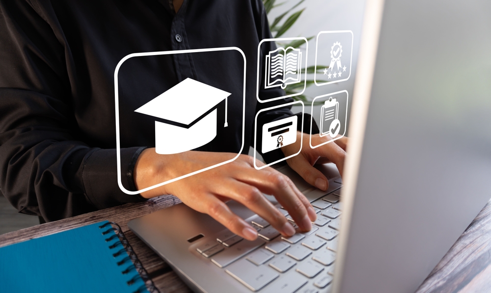 Uma pessoa digita em um notebook com ícones virtuais de um teto de graduação, livros, aprovação e certificados. Conceito de e-learning
