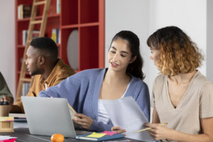 Jovens estudantes analisando documentos e fazendo anotações durante sessão de estudos, ilustrando o que são citações em textos acadêmicos.