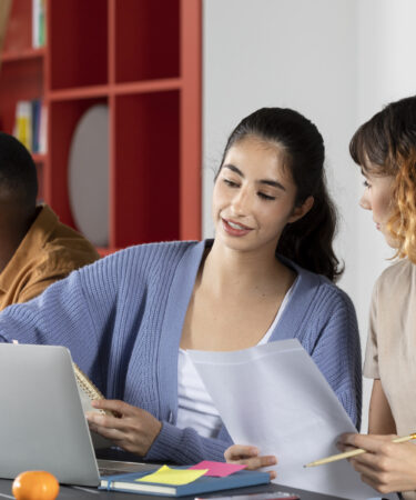 Jovens estudantes analisando documentos e fazendo anotações durante sessão de estudos, ilustrando o que são citações em textos acadêmicos.