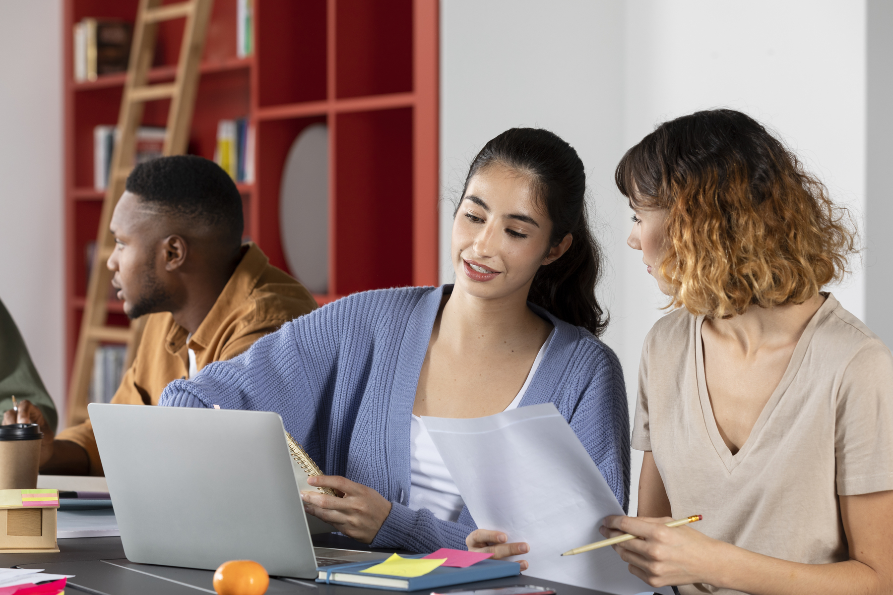 Jovens estudantes analisando documentos e fazendo anotações durante sessão de estudos, ilustrando o que são citações em textos acadêmicos.