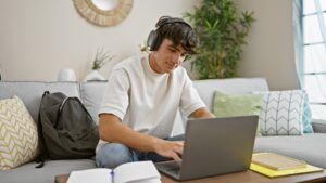 Menino escutando música enquanto estuda em casa.