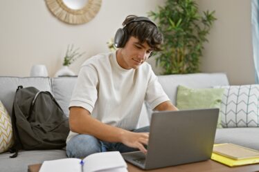 Menino escutando música enquanto estuda em casa.