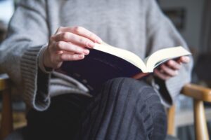 Estudante lendo obra literária enquanto se prepara para o Enem.