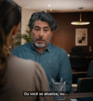 Homem com olhar preocupado em conversa com sua chefe em escritório.