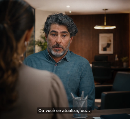 Homem com olhar preocupado em conversa com sua chefe em escritório.