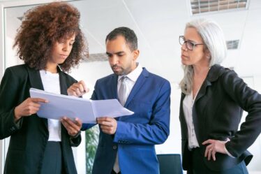 Equipe revisando documentos, exemplificando o que é Gestão Pública por meio do planejamento e da colaboração profissional.