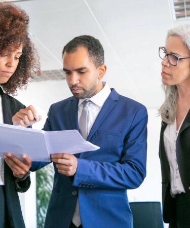 Equipe revisando documentos, exemplificando o que é Gestão Pública por meio do planejamento e da colaboração profissional.