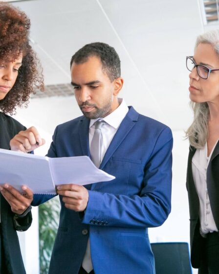 Equipe revisando documentos, exemplificando o que é Gestão Pública por meio do planejamento e da colaboração profissional.