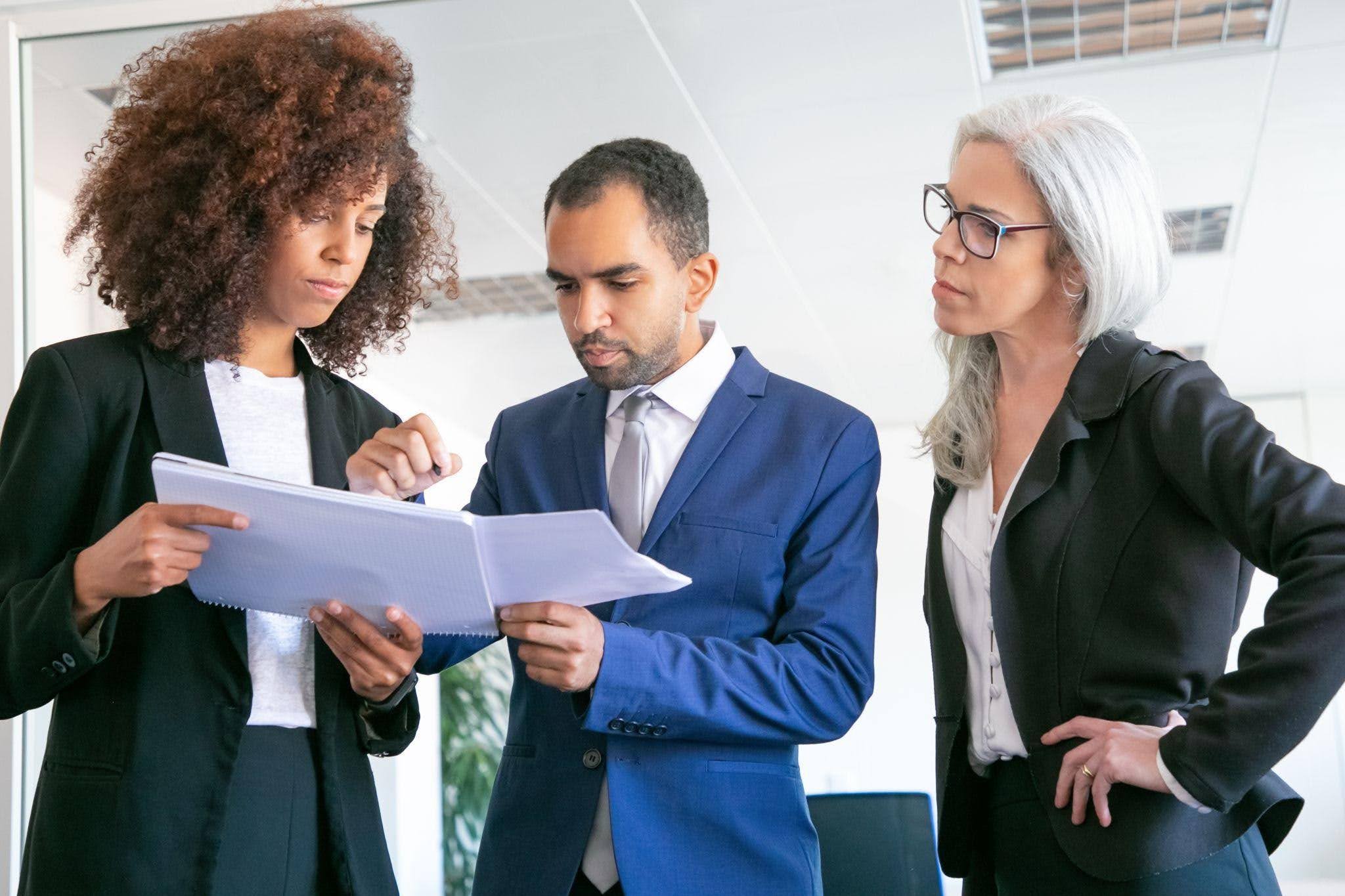 Equipe revisando documentos, exemplificando o que é Gestão Pública por meio do planejamento e da colaboração profissional.