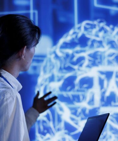 Pessoa analisando um cérebro digital em tela tecnológica, representando o que é neurociência no contexto da inteligência artificial.
