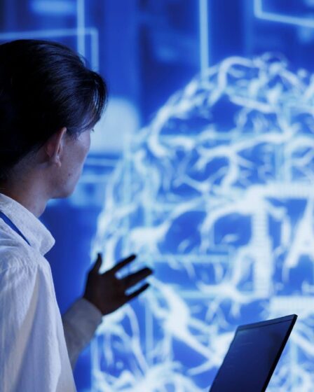 Pessoa analisando um cérebro digital em tela tecnológica, representando o que é neurociência no contexto da inteligência artificial.
