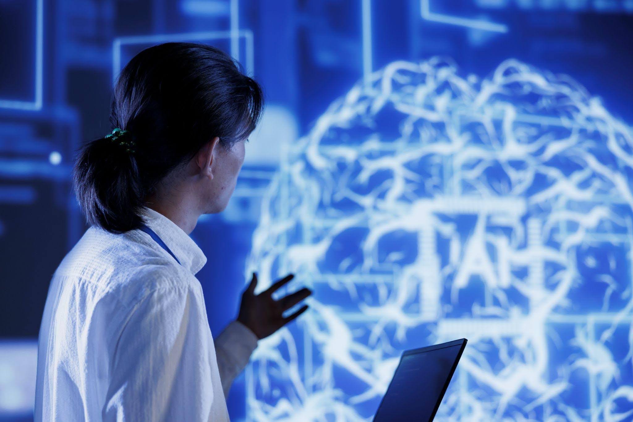 Pessoa analisando um cérebro digital em tela tecnológica, representando o que é neurociência no contexto da inteligência artificial.