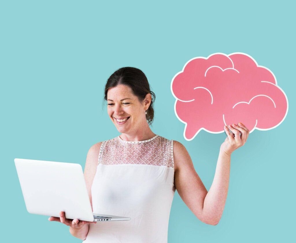 Mulher com ícone de cérebro e notebook representando o que são a Neurociência e os processos cognitivos.