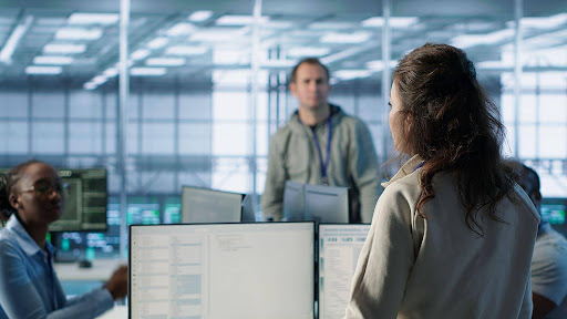 Equipe reunida em ambiente de TI analisando sistemas e processos de gestão da tecnologia da informação.