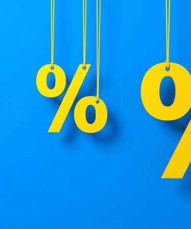 Símbolos de porcentagem amarelos pendurados por fios em um fundo azul vibrante, ilustrando os descontos e as ofertas especiais da Black Friday da Uninter.